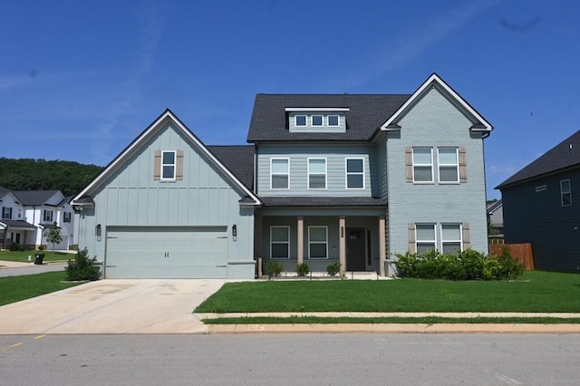 view of front of house featuring covered porch, a front yard, board and batten siding, driveway, and a shingled roof