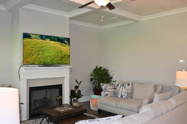 living room with a tile fireplace, beamed ceiling, ornamental molding, wood finished floors, and coffered ceiling