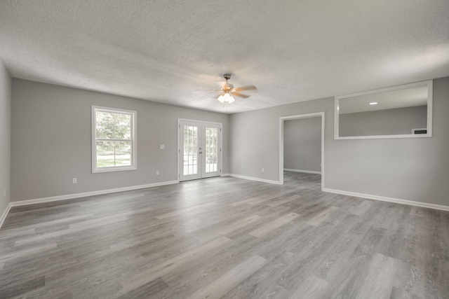 spare room featuring french doors, a textured ceiling, wood-type flooring, and ceiling fan