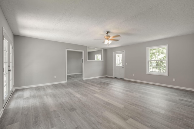 spare room with a textured ceiling, light hardwood / wood-style flooring, and ceiling fan