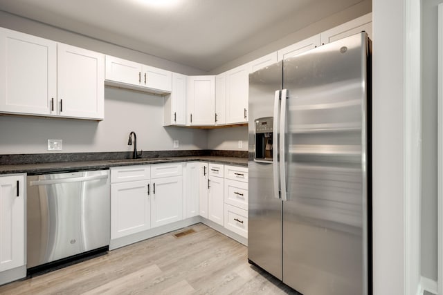 kitchen featuring light hardwood / wood-style flooring, sink, stainless steel appliances, and white cabinets