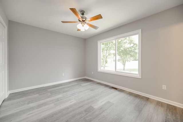 spare room with light wood-type flooring and ceiling fan