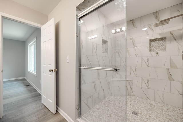 bathroom with hardwood / wood-style floors and an enclosed shower