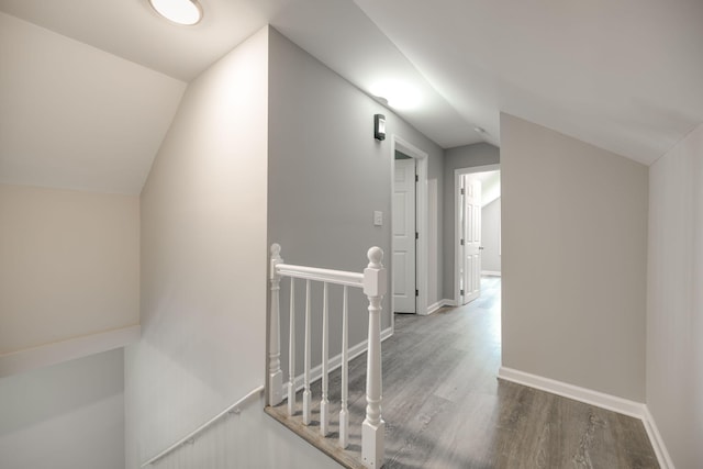 corridor featuring hardwood / wood-style flooring and vaulted ceiling