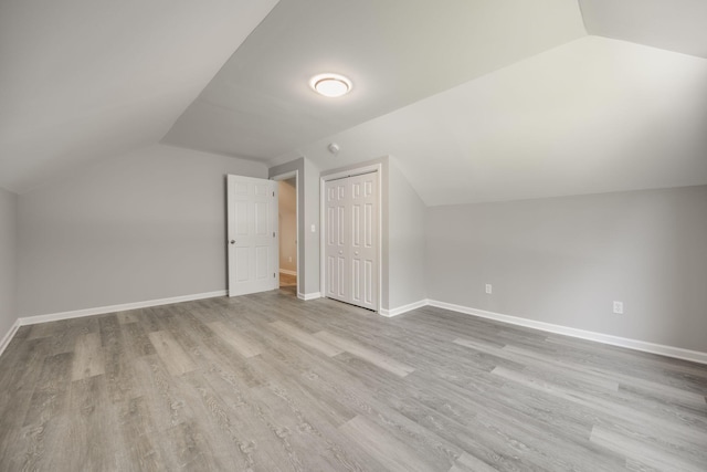 additional living space with lofted ceiling and light hardwood / wood-style flooring