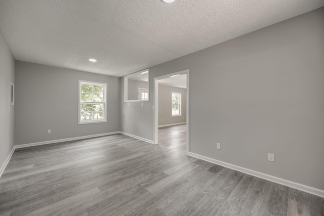 empty room featuring a textured ceiling and light hardwood / wood-style flooring