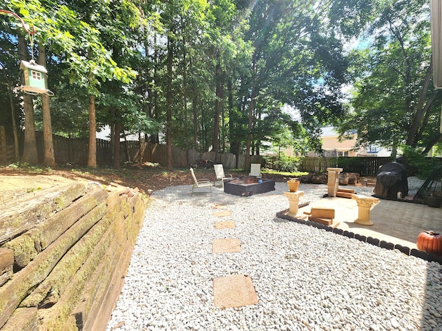 view of yard with a patio and an outdoor fire pit