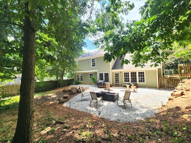 rear view of property featuring a patio area and a fire pit