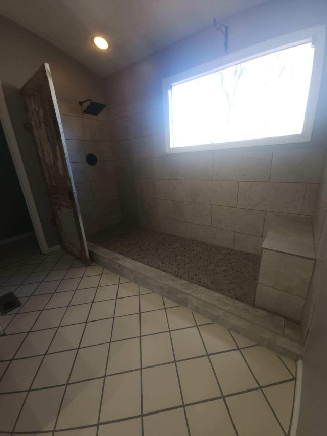 bathroom featuring tile patterned flooring and tiled shower