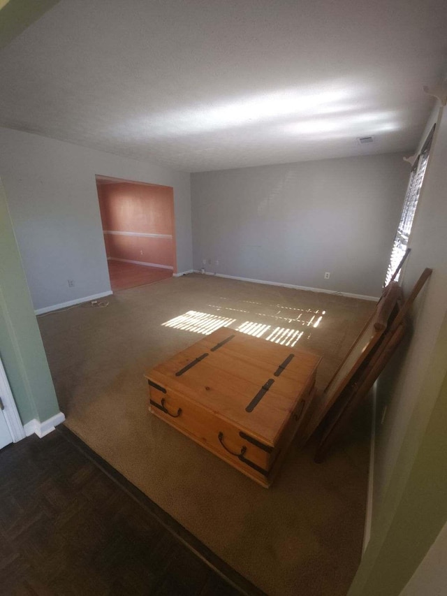 unfurnished room with dark carpet