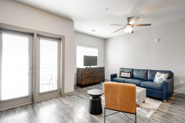 living room featuring ceiling fan and light hardwood / wood-style floors