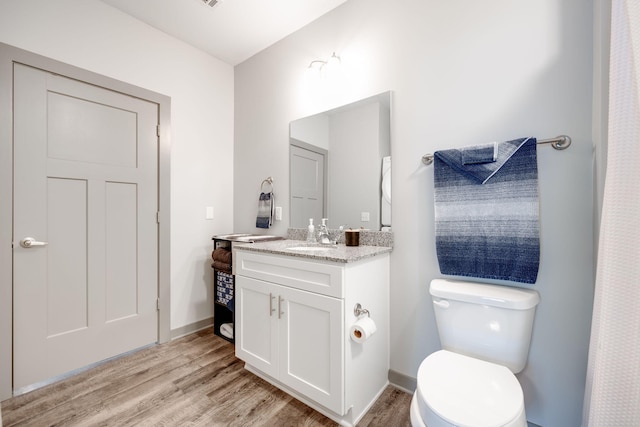 bathroom with vanity, toilet, and hardwood / wood-style floors