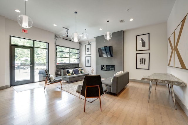 living room with light hardwood / wood-style flooring, an inviting chandelier, and a fireplace