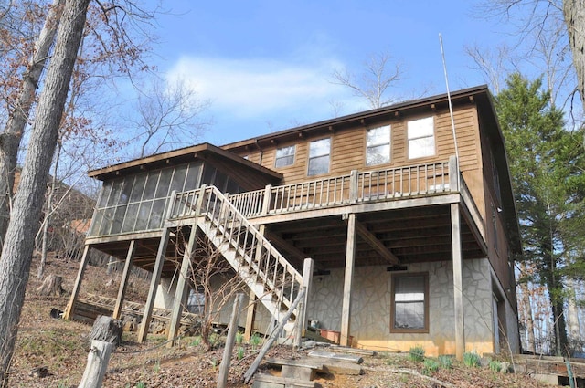 rear view of property with a wooden deck and a sunroom