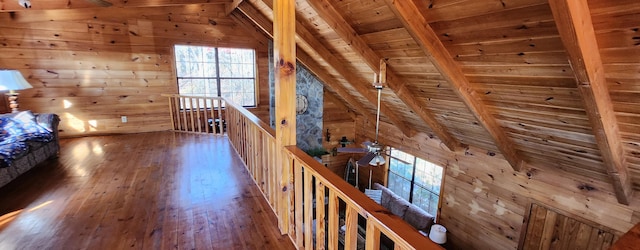 hallway with wood walls, hardwood / wood-style floors, wooden ceiling, and lofted ceiling with beams