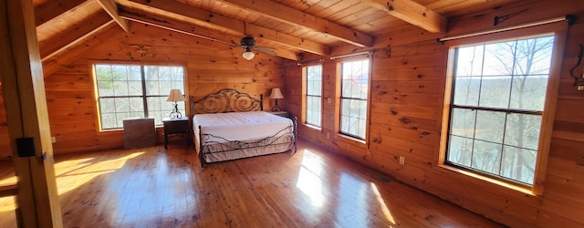 bedroom featuring wooden walls, wood-type flooring, wooden ceiling, and lofted ceiling with beams