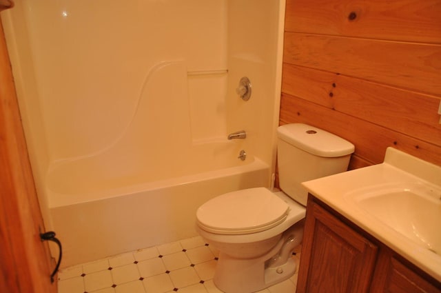 full bathroom with vanity, toilet, wood walls, and bathtub / shower combination