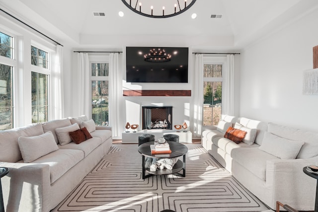 living room with lofted ceiling, a wealth of natural light, and a notable chandelier