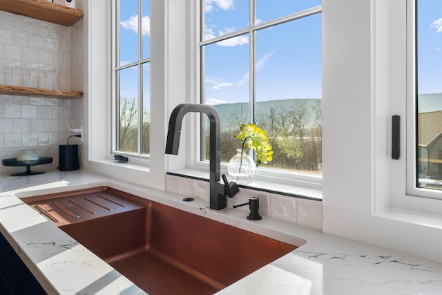 interior space with light stone countertops and sink