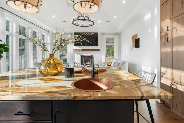 dining space with vaulted ceiling, a notable chandelier, sink, and dark hardwood / wood-style flooring