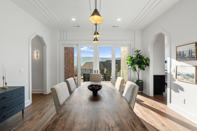 dining space with ornamental molding and dark hardwood / wood-style flooring