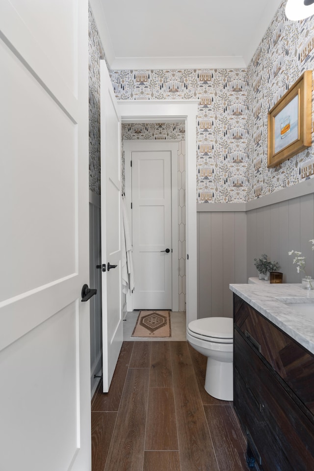 bathroom with crown molding, vanity, toilet, and wood-type flooring