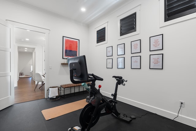 exercise area featuring hardwood / wood-style flooring and crown molding