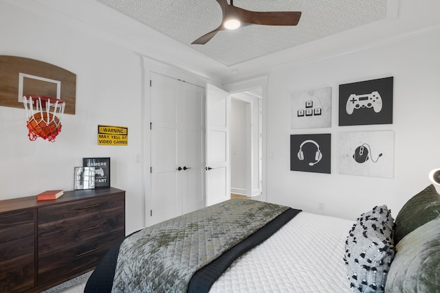 bedroom featuring a closet, ceiling fan, and a textured ceiling