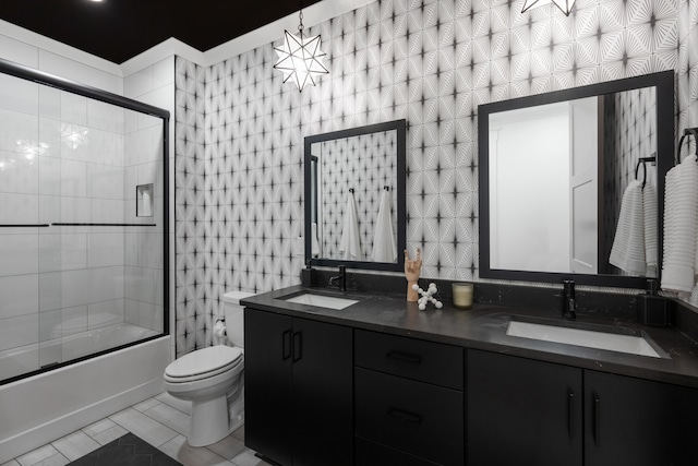 full bathroom featuring tile patterned floors, toilet, bath / shower combo with glass door, and vanity