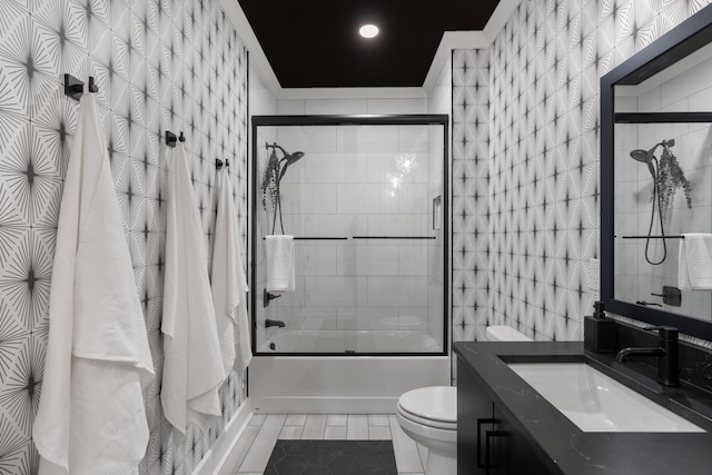 full bathroom with tile patterned floors, enclosed tub / shower combo, toilet, and vanity