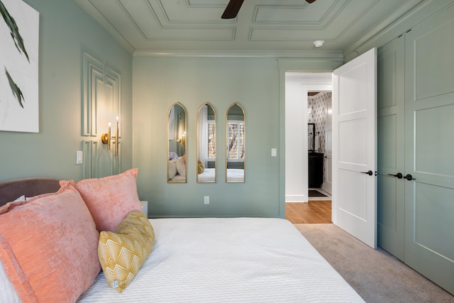 carpeted bedroom with crown molding and ceiling fan