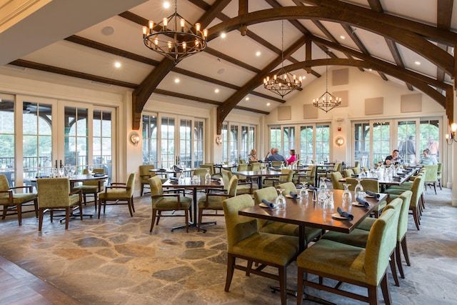 dining area with french doors, beamed ceiling, high vaulted ceiling, and an inviting chandelier