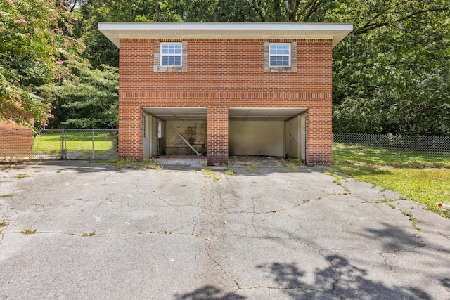 view of front facade featuring fence, driveway, a gate, brick siding, and a carport