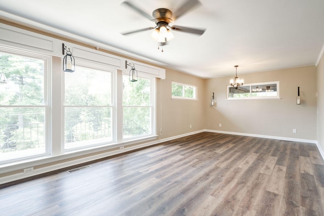 empty room featuring ceiling fan with notable chandelier and hardwood / wood-style flooring