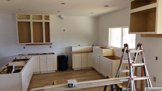 kitchen with white cabinetry, light wood-style flooring, and a sink