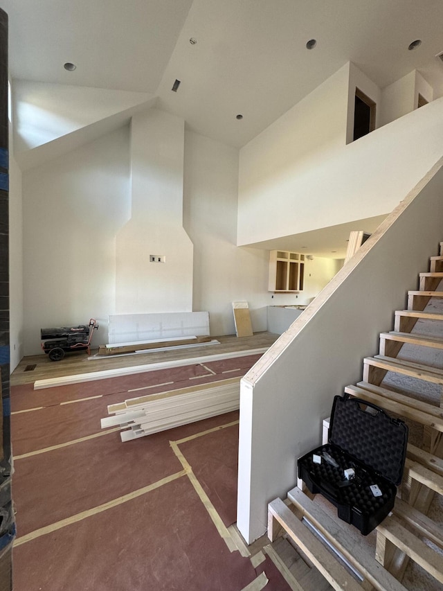 stairway featuring high vaulted ceiling