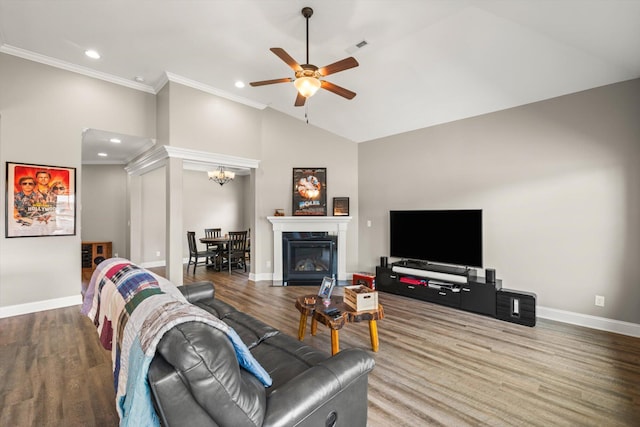 living room with ornamental molding, ceiling fan with notable chandelier, high vaulted ceiling, and hardwood / wood-style flooring