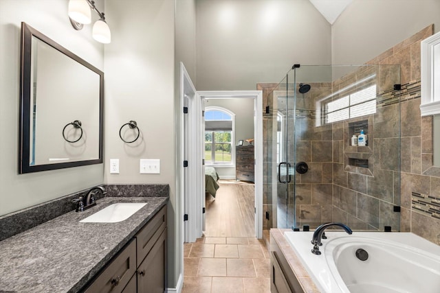 bathroom featuring plus walk in shower, tile patterned flooring, lofted ceiling, and vanity