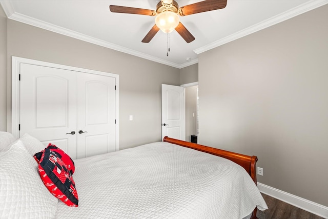 bedroom featuring a closet, baseboards, crown molding, and dark wood finished floors