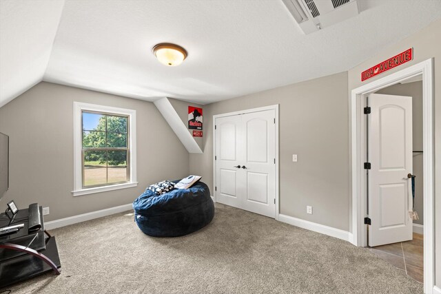 interior space with light carpet and vaulted ceiling