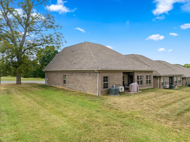 rear view of property featuring cooling unit, a yard, and a patio area