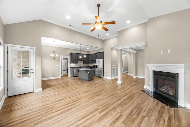 living area featuring ceiling fan with notable chandelier, visible vents, light wood-style flooring, and baseboards