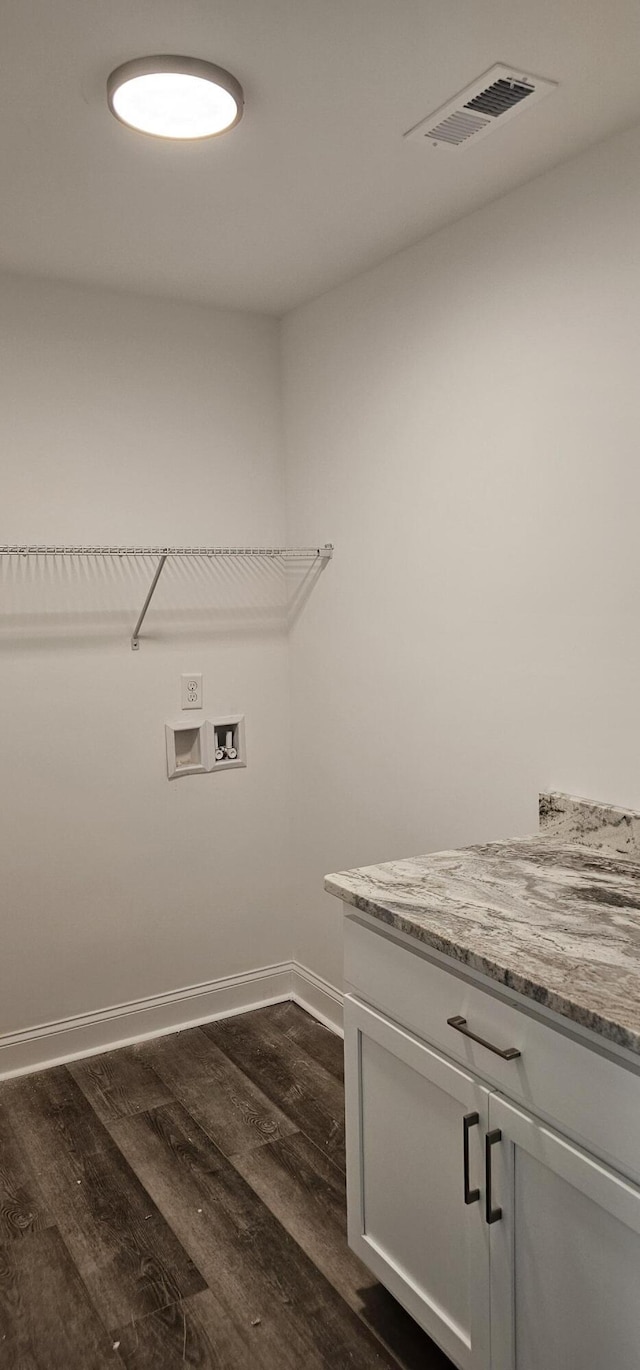 laundry room with washer hookup, dark hardwood / wood-style flooring, and cabinets