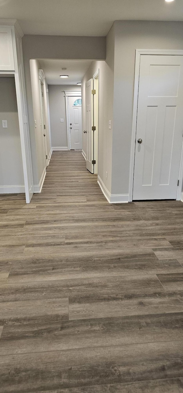 hallway featuring baseboards and light wood finished floors