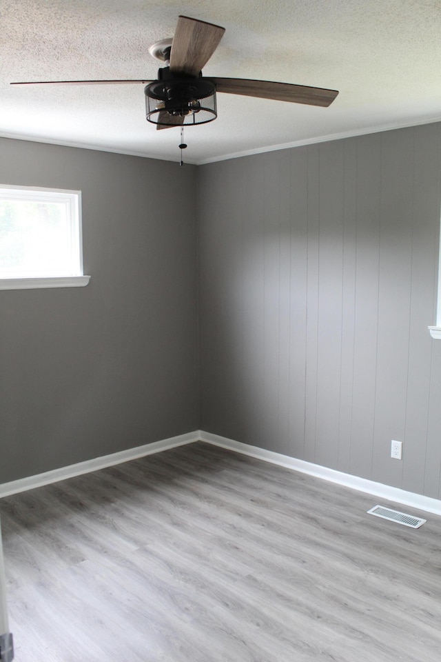 empty room with a textured ceiling, ceiling fan, and hardwood / wood-style flooring