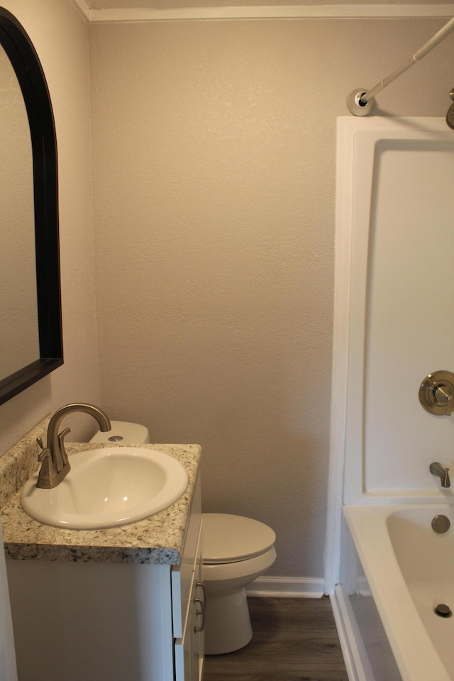 full bathroom featuring vanity, toilet, wood-type flooring, and shower / washtub combination