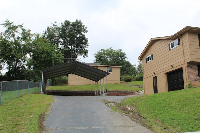 exterior space with a garage, a carport, and a lawn