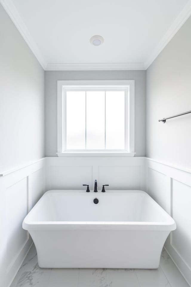 bathroom with crown molding and a bathing tub