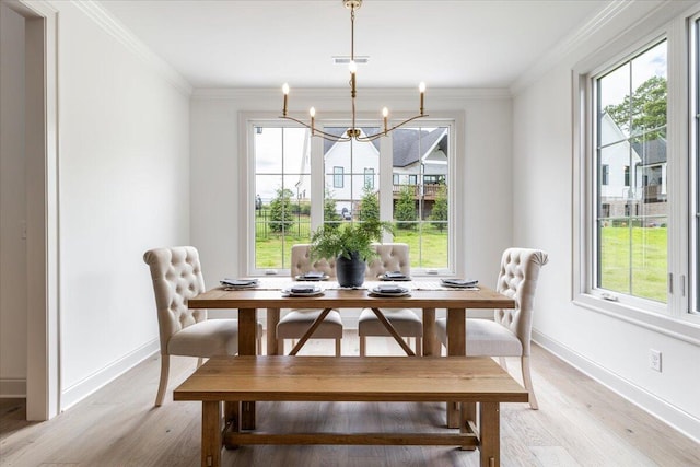 dining space featuring ornamental molding, plenty of natural light, a chandelier, and light hardwood / wood-style floors