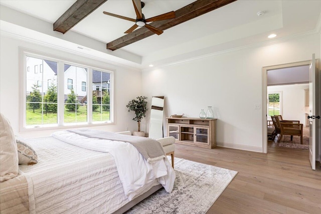 bedroom with multiple windows, ceiling fan, light hardwood / wood-style floors, and beamed ceiling